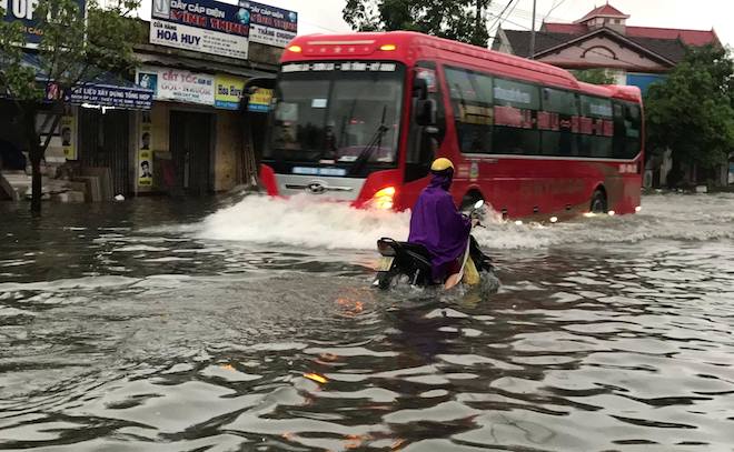 Áp thấp nhiệt đới gây mưa lớn, ngập sâu ở nhiều tuyến đường: Chỉ có các loại ô tô lớn mới có thể di chuyển, người đi xe máy, xe đạp đều rất khó khăn giữa mênh mông biển nước.