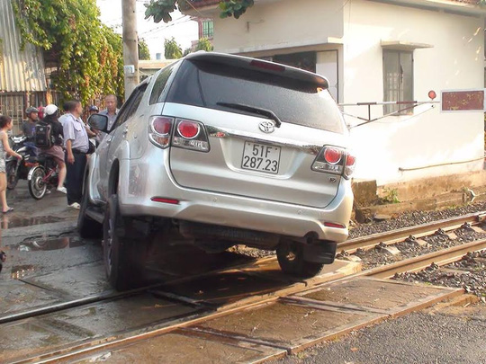 Sụp bánh ngay đường ray, ô tô 7 chỗ buộc tàu hỏa thắng khẩn - Ảnh 1.