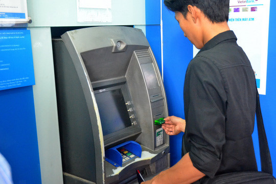 Vừa rút tiền từ ATM vừa lo - Ảnh 1.