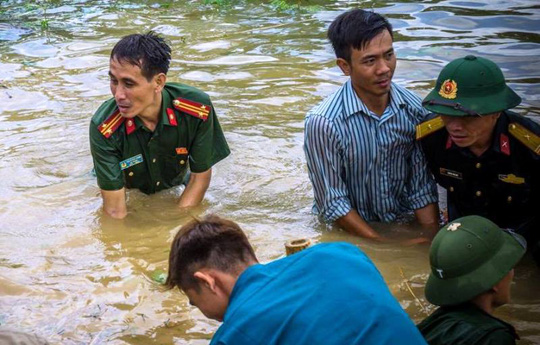 Công an, bộ đội dầm mình trong nước ăn vội, giúp dân chống lũ dữ - Ảnh 1.