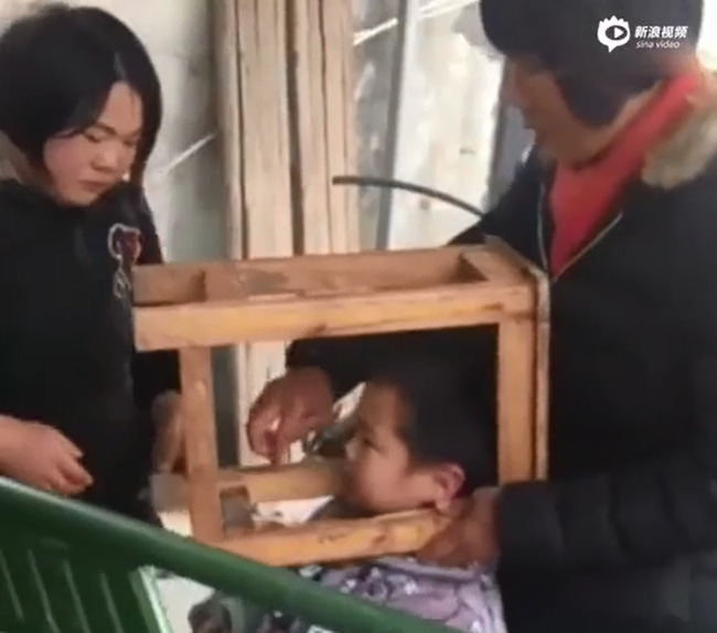 Trung Quốc: Bé trai nghịch ngợm kẹt đầu vào ghế gỗ, người lớn đứng bên cạnh cười sằng sặc - Ảnh 3.