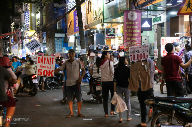 Nhiều nhân viên cửa hàng thời trang ở Sài Gòn cầm bảng giá tràn ra đường chào mời khách dịp cận Tết - Ảnh 9.