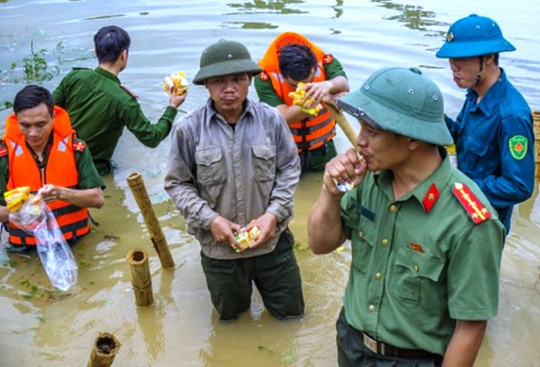 Công an, bộ đội dầm mình trong nước ăn vội, giúp dân chống lũ dữ - Ảnh 10.