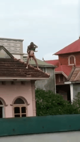 [NÓNG] Nam thanh niên xăm trổ ôm con leo lên nóc nhà 3 tầng, nhảy qua các mái nhà - Ảnh 3.