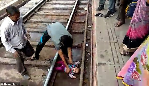 Mẹ trượt tay đánh rơi con xuống đường ray, em bé kỳ diệu thoát chết trong gang tấc khi chiếc xe lửa chạy ngang qua - Ảnh 2.