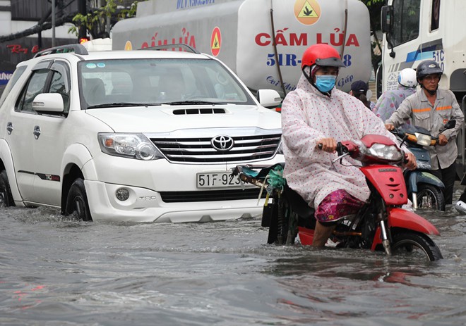 Xe hơi nằm la liệt khắp phố TP.HCM do ngập nước chết máy - Ảnh 4.