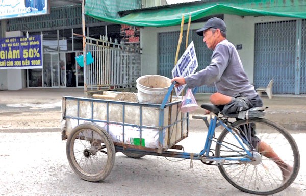 Ông lão tật nguyền bán vé số dành tiền vá đường - Ảnh 1.