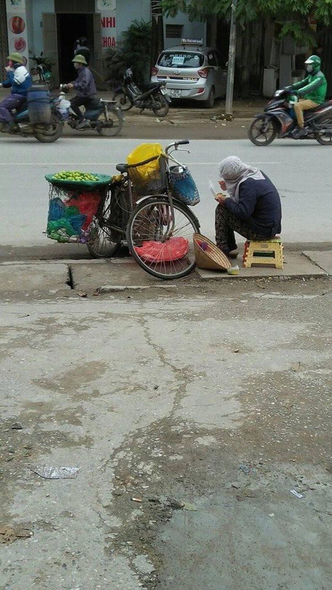 Nhìn người bán hàng rong ăn vội suất cơm hộp bên đường dưới tiết trời 11 độ, bạn nghĩ gì?  - Ảnh 1.