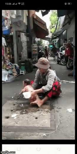 Người phụ nữ ngồi giữa đường, giội nước vào đứa trẻ đỏ hỏn gây phẫn nộ - Ảnh 1.
