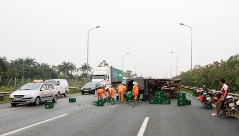 Xe tải chở bia lật trên đường Thăng Long, tài xế phải đi cấp cứu - Ảnh 1.