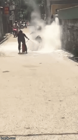 Xe máy bốc cháy dữ dội giữa đường, cô gái dùng nước dập lửa khiến bao người sửng sốt - Ảnh 3.