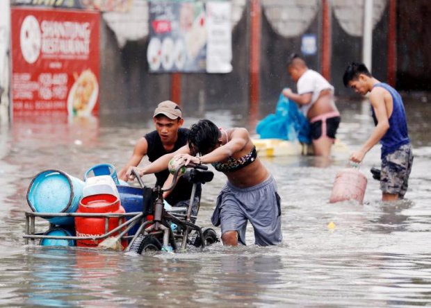 Người dân Philippines oằn mình với ngập lụt vì bão Sơn Tinh - Ảnh 4.