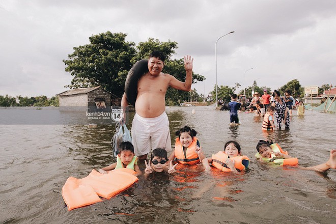 Nước vừa rút lại lên, người già trẻ nhỏ tiếp tục ùa ra đường tỉnh lộ vô tư bơi lội khi phương tiện bị cấm lưu thông - Ảnh 13.