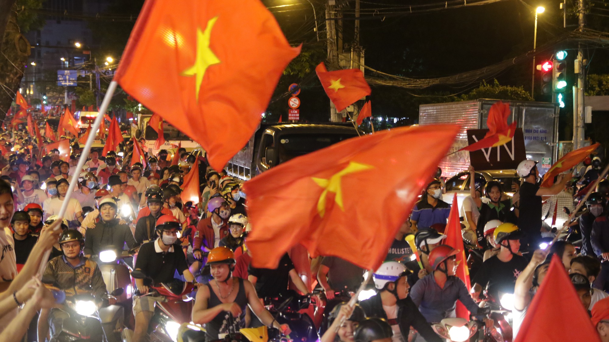 Người Sài Gòn bất chấp nguy hiểm leo lên nóc xe mừng chiến thắng của U23 Việt Nam - Ảnh 14.