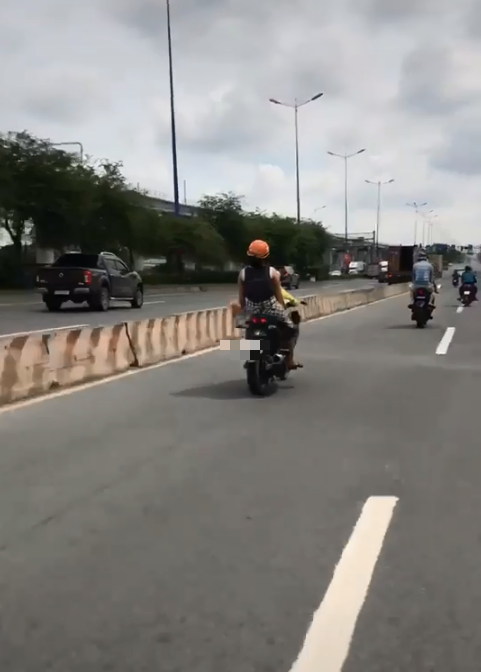Người mẹ ung dung để con nhỏ lái xe máy lao phăng phăng trên đường khiến cộng đồng mạng tranh cãi - Ảnh 1. Người mẹ ung dung để con nhỏ lái xe máy lao phăng phăng trên đường khiến cộng đồng mạng tranh cãi - Ảnh 1.