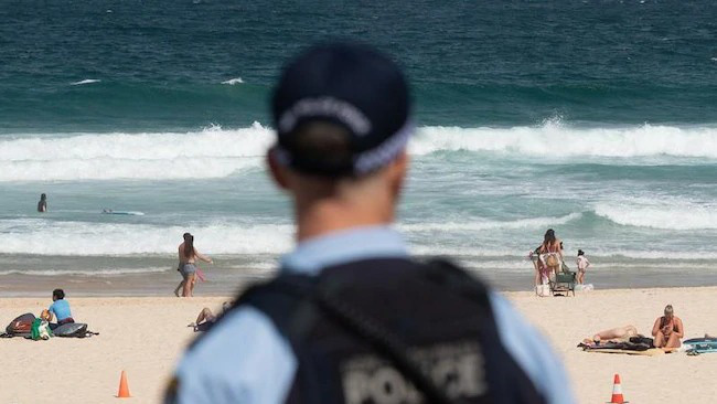 Bị yêu cầu rời khỏi bãi biển đang đóng cửa vì đại dịch Covid-19, người đàn ông Úc tấn công và nhổ nước bọt lên người cảnh sát - Ảnh 2.
