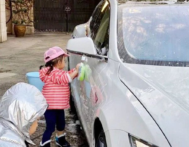 Bé gái đứng rửa xe ô tô bên đường để kiếm tiền, ai nấy rưng rưng thương cảm cho đến khi biết sự thật thì choáng váng - Ảnh 1.