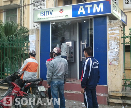 Khách hàng chờ rút tiền tại một cây ATM của ngân hàng BIDV.