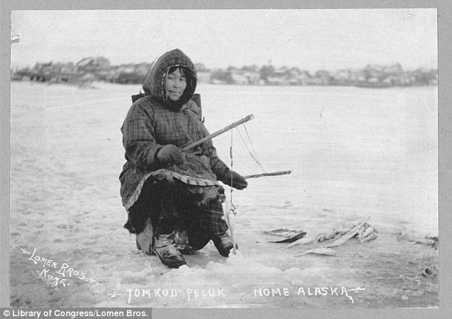 Ice fishing: A woman poses over an ice fishing hole, several successful fish seen at her left-hand side