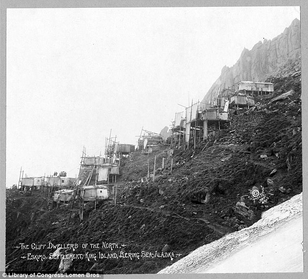 Homes' accommodations: Stacked homes of cliff dwellers along King Island in Bering Sea, Alaska are seen just off the side of snow