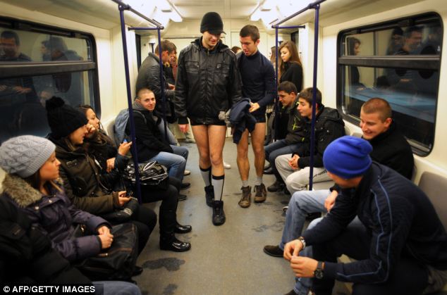 Under-dressed on the underground: Fellow passengers smile as two commuters board the train holding their trousers in the Bulgarian capital