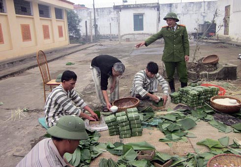 Quản giáo và phạm nhân đang gói bánh chưng phục vụ Tết trong trại giam