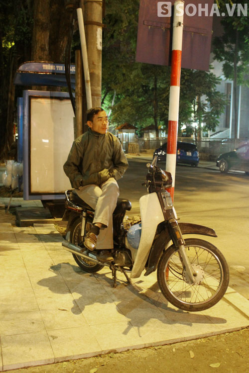 Một anh lái xe ôm đăm chiêu đợi khách trong giá rét (cạnh UBND TP Hà Nội).
