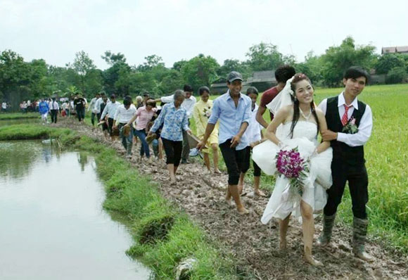 Dù phải chú rể phải đi ủng, cô dâu vén váy cao để đi qua quãng đường bùn lầy thế nhưng cặp đôi vẫn rạng ngời hạnh phúc