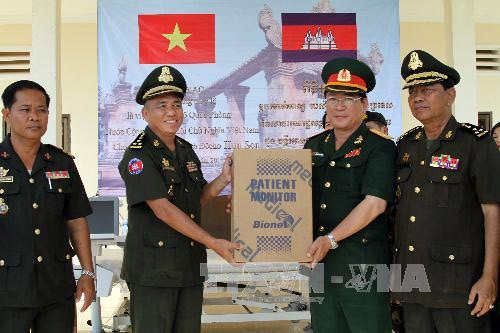 Đại tá Nguyễn Anh Dũng, Trưởng Tùy viên Quốc phòng Việt Nam tại Campuchia (người thứ 3 từ trái sang) trao tượng trưng món quà của Bộ Quốc phòng Việt Nam cho Đại tướng Kong Saly, Cục trưởng Cục Quân y Campuchia (người thứ hai từ trái sang)