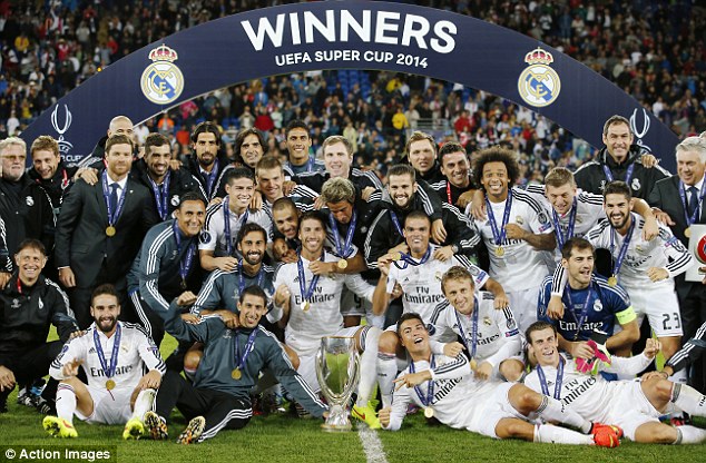 Just getting started: Real Madrid players pose with the UEFA European Super Cup trophy on the pitch