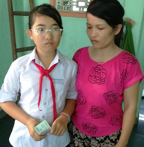chị Võ Thị Hồng và bé Hồ Minh Hiếu xúc động nhận số tiền các nhà hảo tâm trao tặng