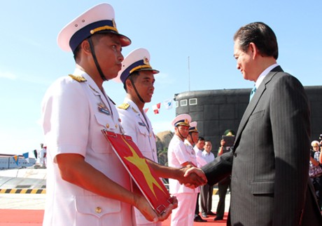 Thủ tướng Nguyễn Tấn Dũng tận tay trao quốc kỳ cho lực lượng hai tàu ngầm Hà Nội và TP Hồ Chí Minh. - Ảnh: Nguyễn Đông