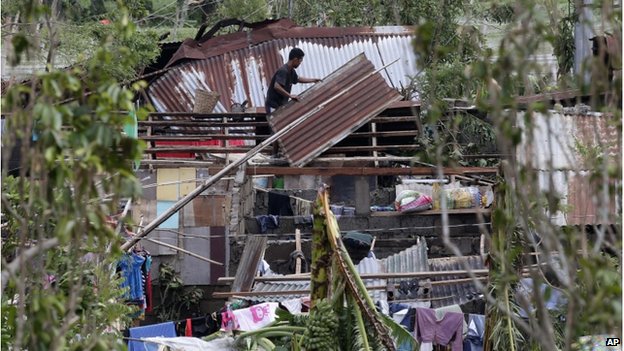 Người dân lợp lại mái nhà sau khi bị gió bão Rammasun thổi bay ở thủ đô Manila, Philippines.