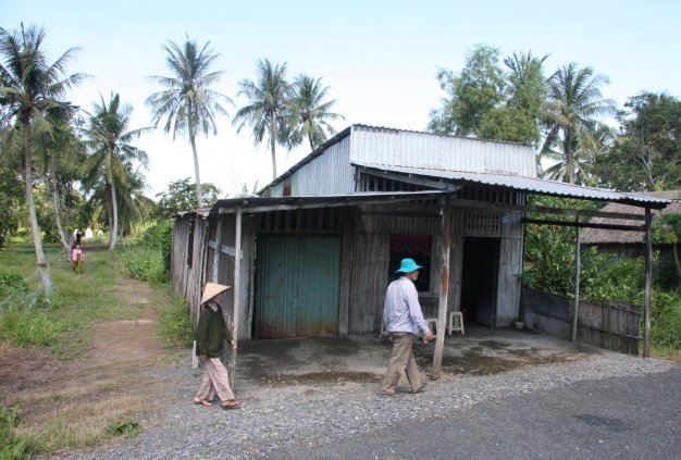 Bà Nguyễn Thị Anh (con dâu bác Ba Phi) đang sống trong căn nhà đơn sơ. Xưa kia, bác Ba Phi cũng sinh sống trên mảnh đất này. Phía sau là khu mộ bác Ba Phi.