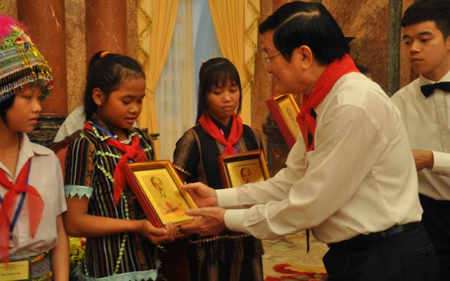 Chủ tịch nước Trương Tấn Sang tặng ảnh chân dung Bác Hồ cho các em tại cuộc gặp. 