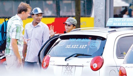 Chi phí vận tải chiếm 11,8% GDP của VN. Trong ảnh: Du khách nước ngoài ngã giá với lái xe taxi. 