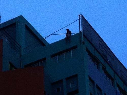Cô gái ngồi trên nóc tòa nhà định tự tử.