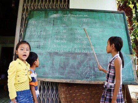 “Cô giáo tí hon” Huỳnh Hoàng Anh đang dạy tập đọc, tập viết cho các cháu nhỏ ở địa phương.