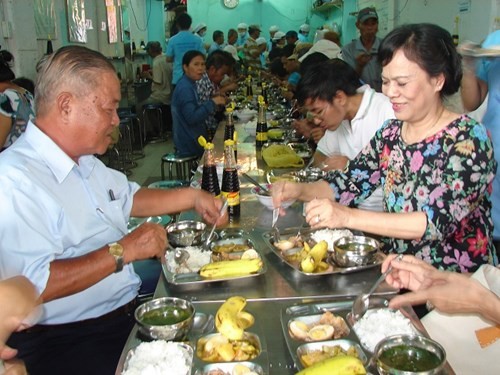 Bà Mai Thị Hạnh, phu nhân Chủ tịch nước Trương Tấn Sang, vui vẻ dùng bữa cơm với người nghèo.