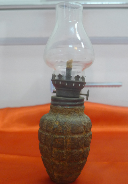 Chiếc đèn dầu với phần dưới làm từ vỏ đạn hạt na