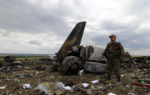 Một tay súng ly khai thân Nga đứng bảo vệ hiện trường chiếc máy bay vận tải quân sự Il-76 của quân đội Ukraine bị bắn rơi ở thành phố Luhansk.
