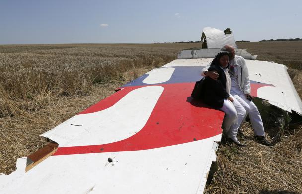 Ông bà George và Angela Dyczynski ngồi trên một mảnh xác máy bay MH17 rơi tại miền đông Ukraine. Con gái của cặp vợ chồng người Australia là hành khách trên chiếc máy bay xấu số.