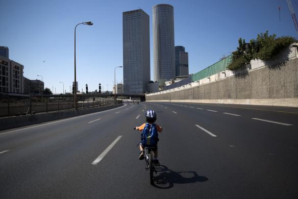 Một cậu bé đạp xe trên đường phố vắng tanh ở Yom Kippur, Tel Aviv, Israel.