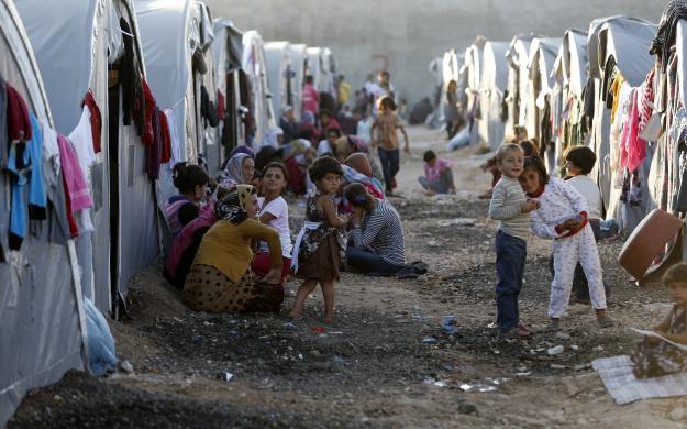 Người tị nạn đến từ thị trấn Kobani của Syria ngồi trước những túp lều trong trại tị nạn ở thị trấn Suruc, tỉnh Sanliurfa, Thổ Nhĩ Kỳ.