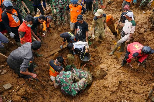 Các thành viên đội tìm kiếm và cứu hộ đào bới thi thể một nạn nhân trong vụ lở đất kinh hoàng ở làng Jemblung, huyện Banjarnegara, miền Trung đảo Java, Indonesia. Vụ việc đã khiến ít nhất 32 người chết, 76 người mất tích.