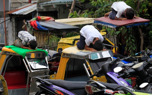 Các thanh niên theo đạo Hồi cầu nguyện trên nóc xe taxi ba bánh trong tháng lễ Ramadan ở Manila, Philippines.