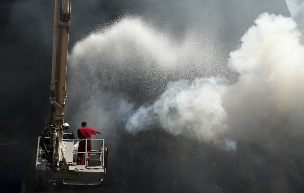 Lính cứu hỏa cố gắng dập tắt đám cháy tại một chợ bán thảm ở Benghazi, Libya.