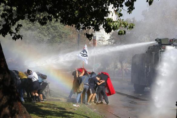 Cảnh sát dùng vòi rồng phun nước để giải tán sinh viên biểu tình đòi cải cách hệ thống giáo dục ở Santiago, Chile.