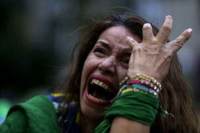 Một fan hâm mộ bóng đá Brazil khóc khi bà nhìn thấy nhóm của cô bị đánh bại trong một chương trình truyền hình trực tiếp của trận bán kết World Cup bóng đá trận đấu giữa Brazil và Đức, trong Belo Horizonte, Brazil, thứ Ba 8 tháng 7, 2014. (AP Photo / Bruno Magalhaes) ORG XMIT : XBM122