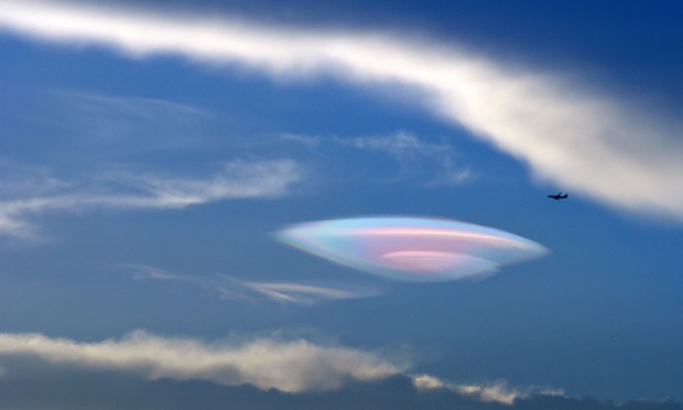 Máy bay bay qua một đám mây hình UFO trên bầu trời ở thành phố Hạ Môn, Trung Quốc.